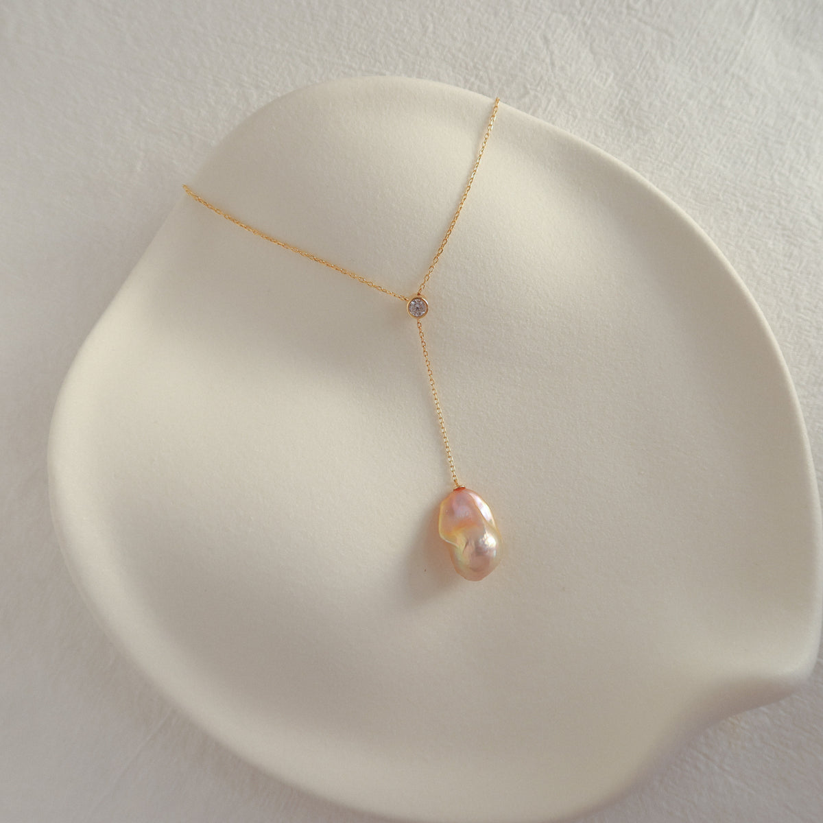 Vela Baroque Pearl Necklace featuring an organic baroque freshwater pearl and an adjustable sliding cubic zirconia detail on a gold chain.