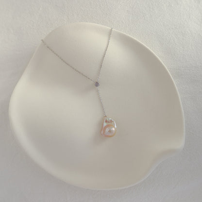Vela Baroque Pearl Necklace showing the adjustable sliding cubic zirconia accent and organic freshwater baroque pearl on a silver chain.