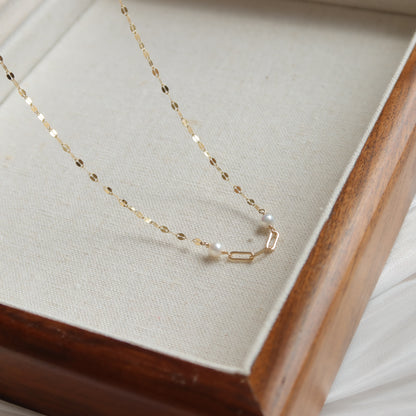 Gold necklace with pearls on a wooden stand