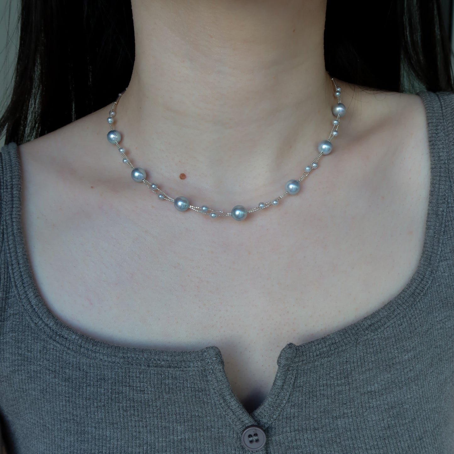 Blue Akoya Pearl necklace worn by a person with a plain background