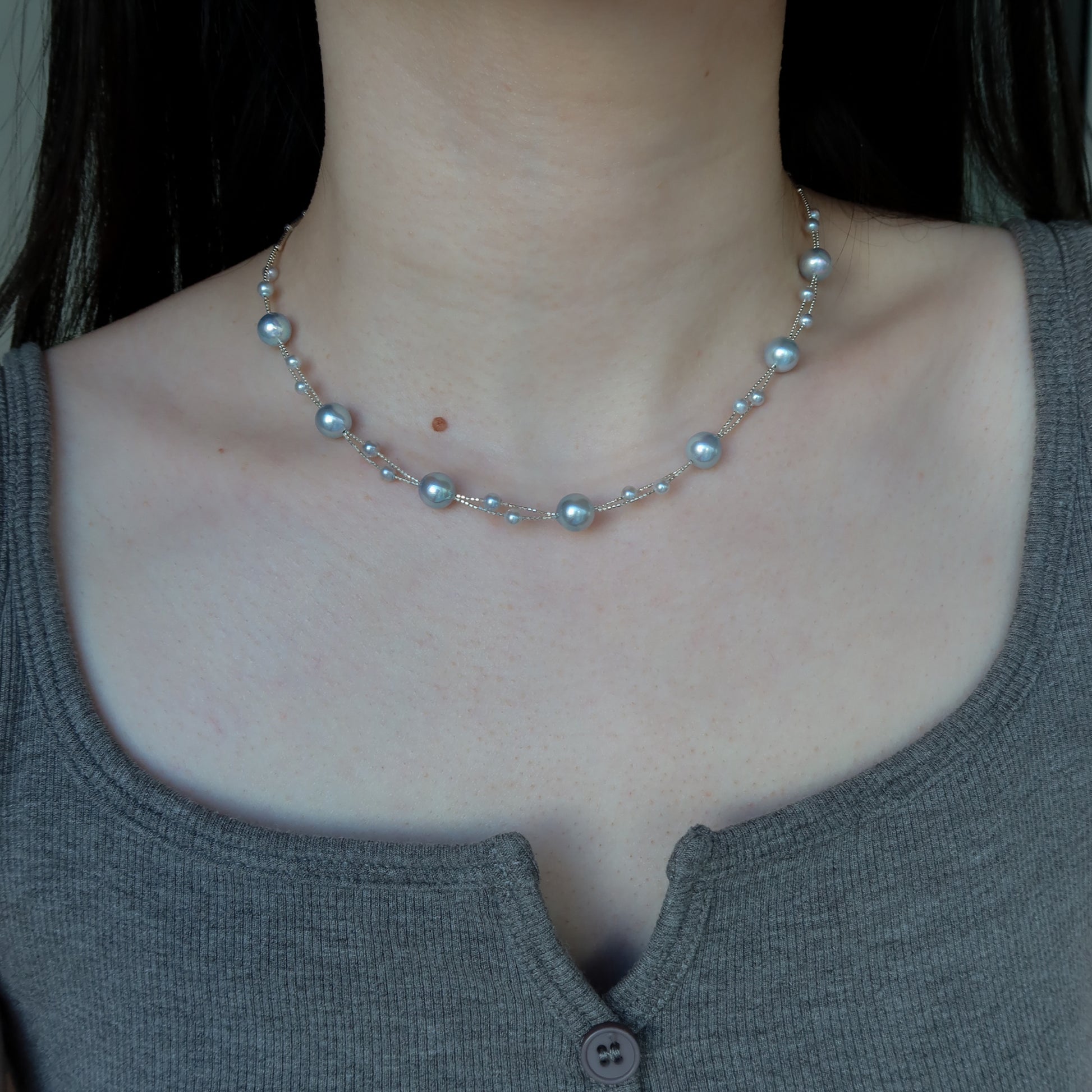 Blue Akoya Pearl necklace worn by a person with a plain background