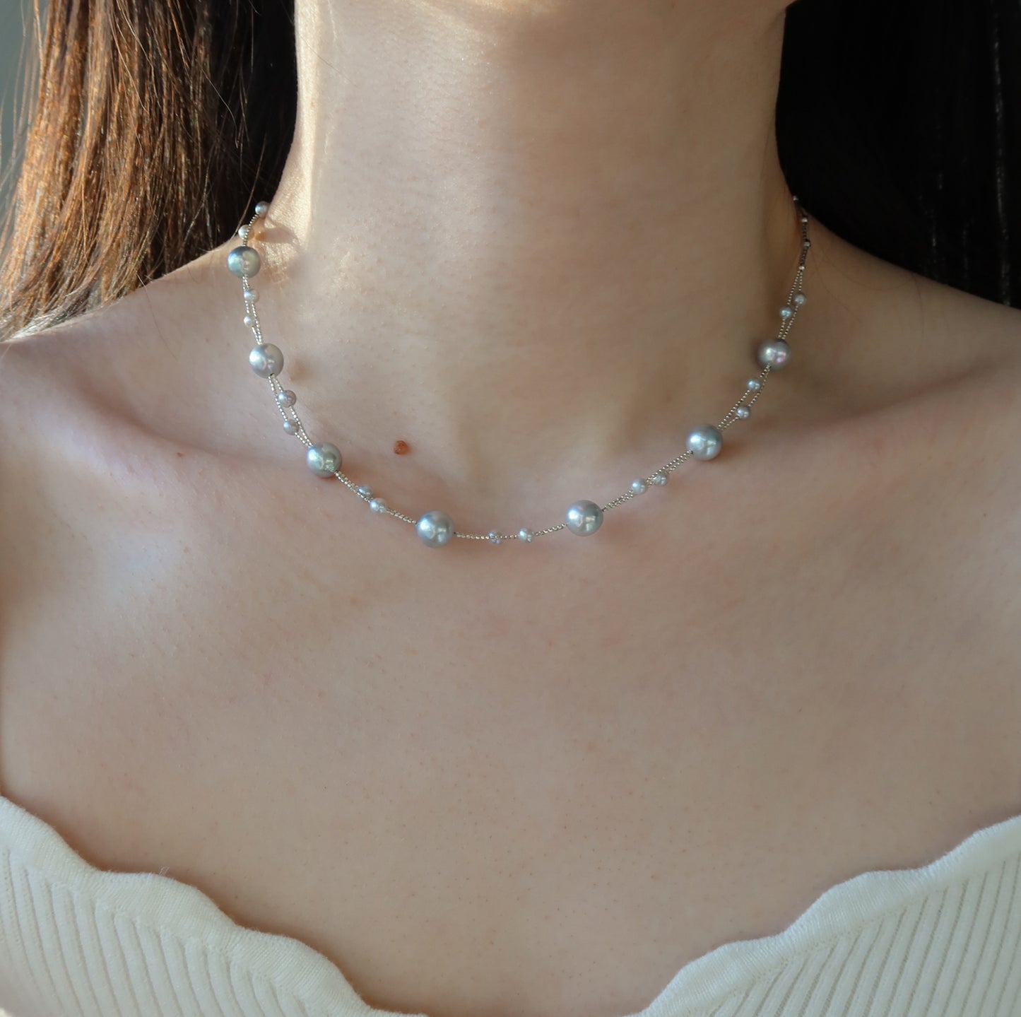 Blue Akoya Pearl necklace worn by a person with a neutral background