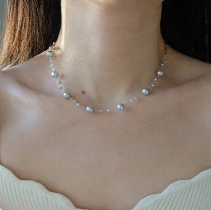Blue Akoya Pearl necklace worn by a person with a neutral background