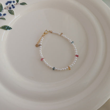 Pearl bracelet with small sapphire beads on a white plate