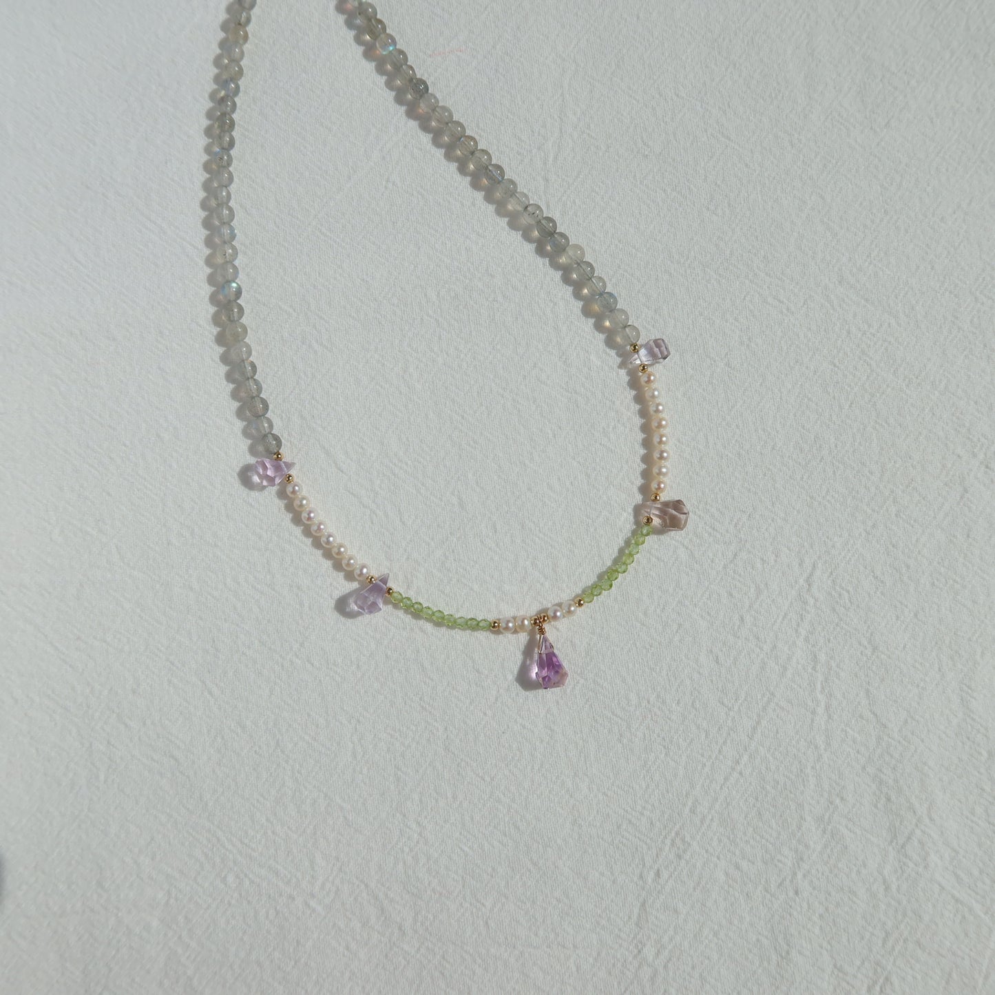 Necklace with gemstones on a light gray background