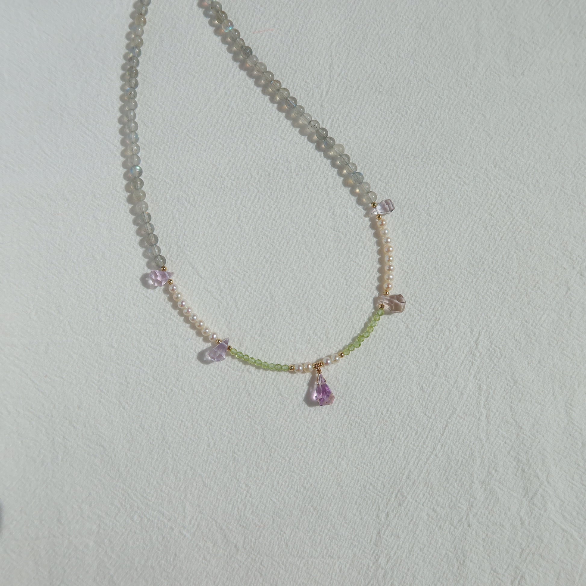 Necklace with gemstones on a light gray background