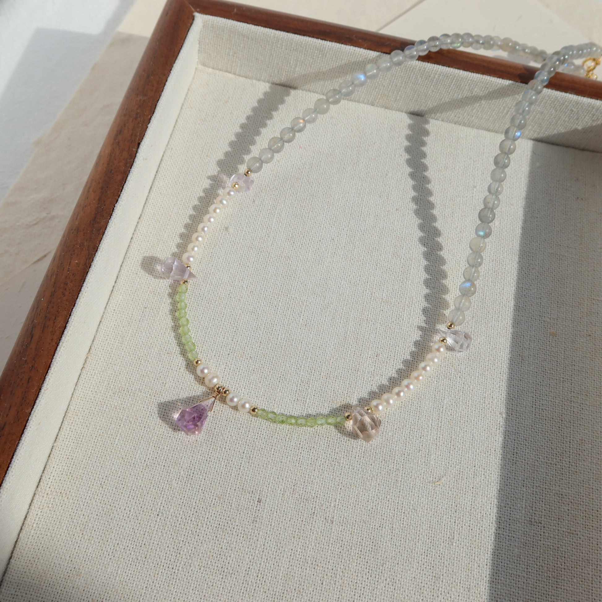 Necklace with beads and gemstones on a light fabric background