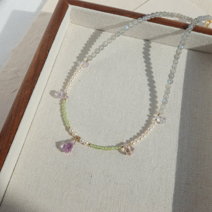 Necklace with beads and gemstones on a light fabric background
