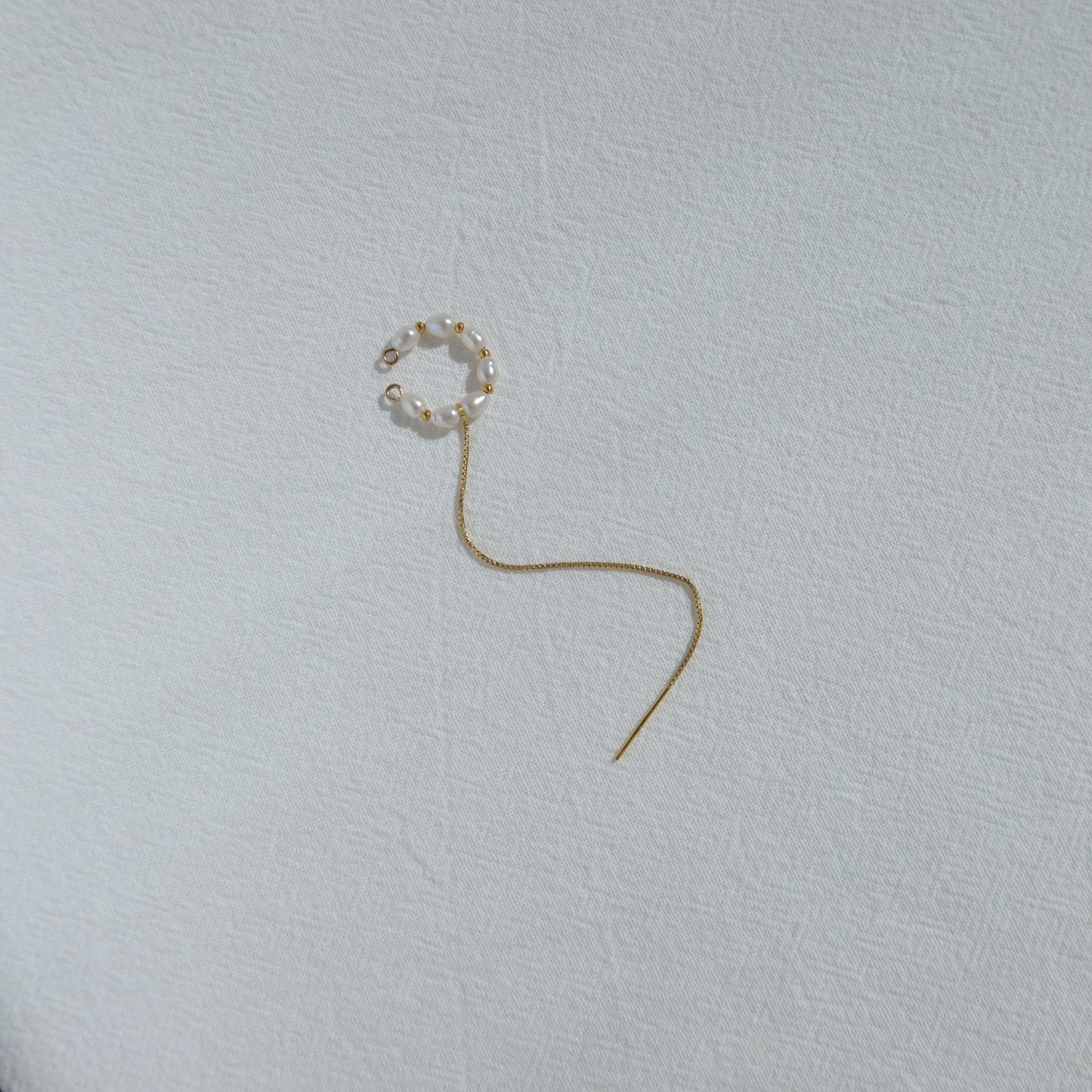 Single earring on a light gray background