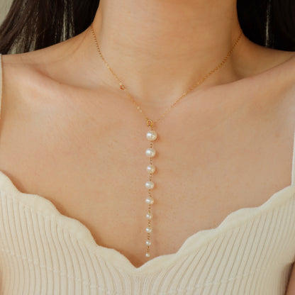 Pearl necklace on a person wearing a beige top
