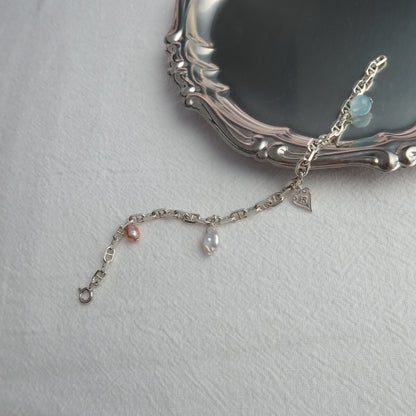 Silver bracelet with charms on a white surface
