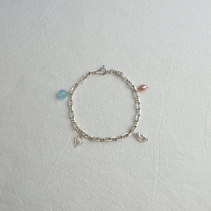Silver bracelet with charms on a light gray background