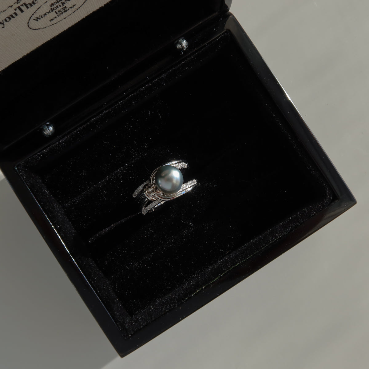 Sirene Tahitian Pearl Ring resting inside a black presentation box, showcasing its 8.7mm platinum-gray Tahitian pearl and twisted pavé silver band.